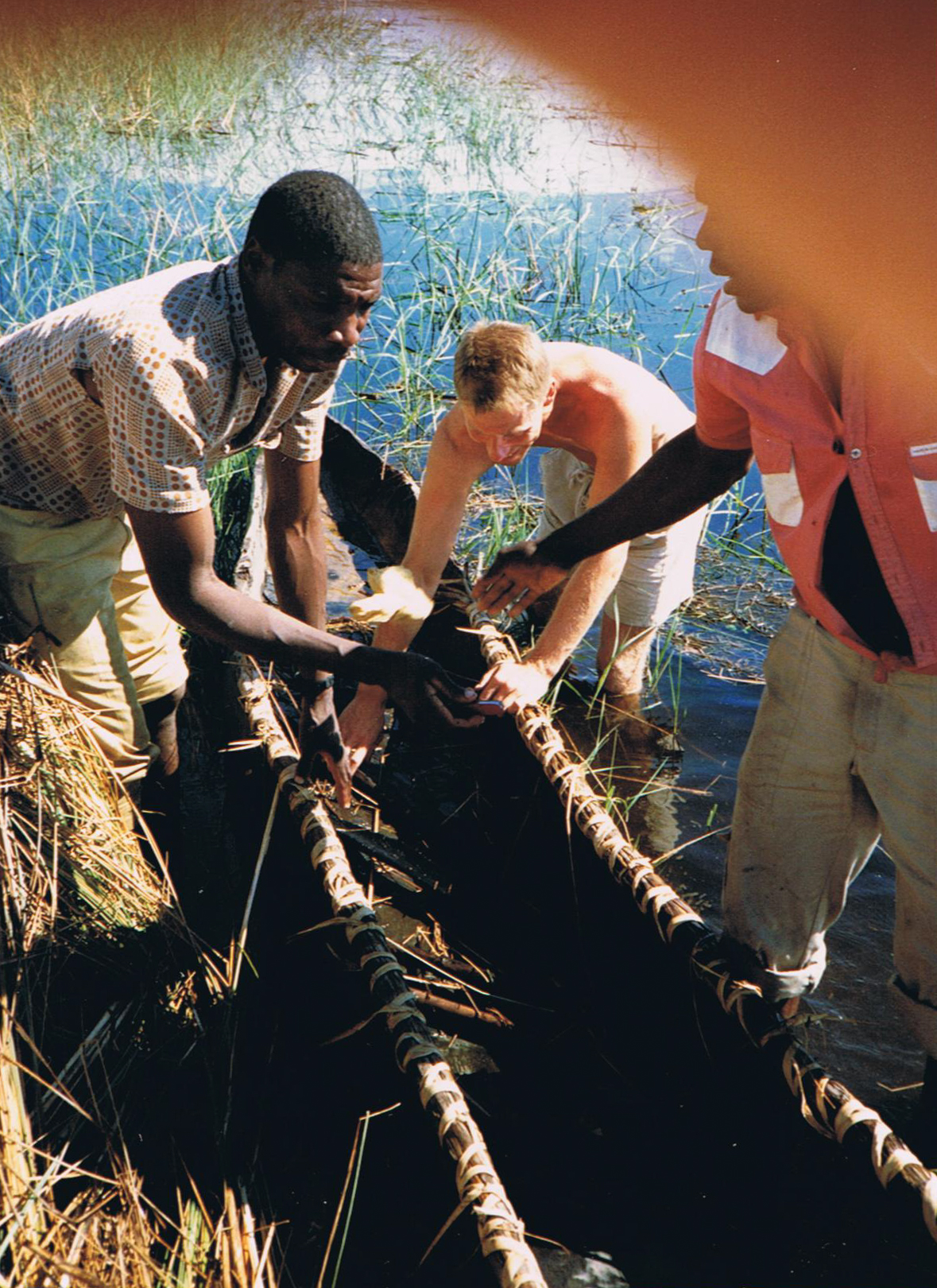 Jerry emptying Moroko canoe of water - Okavanga Delta - Zimbabwe